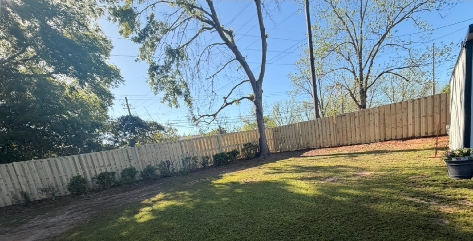 Finished wood picket-style fence around a backyard