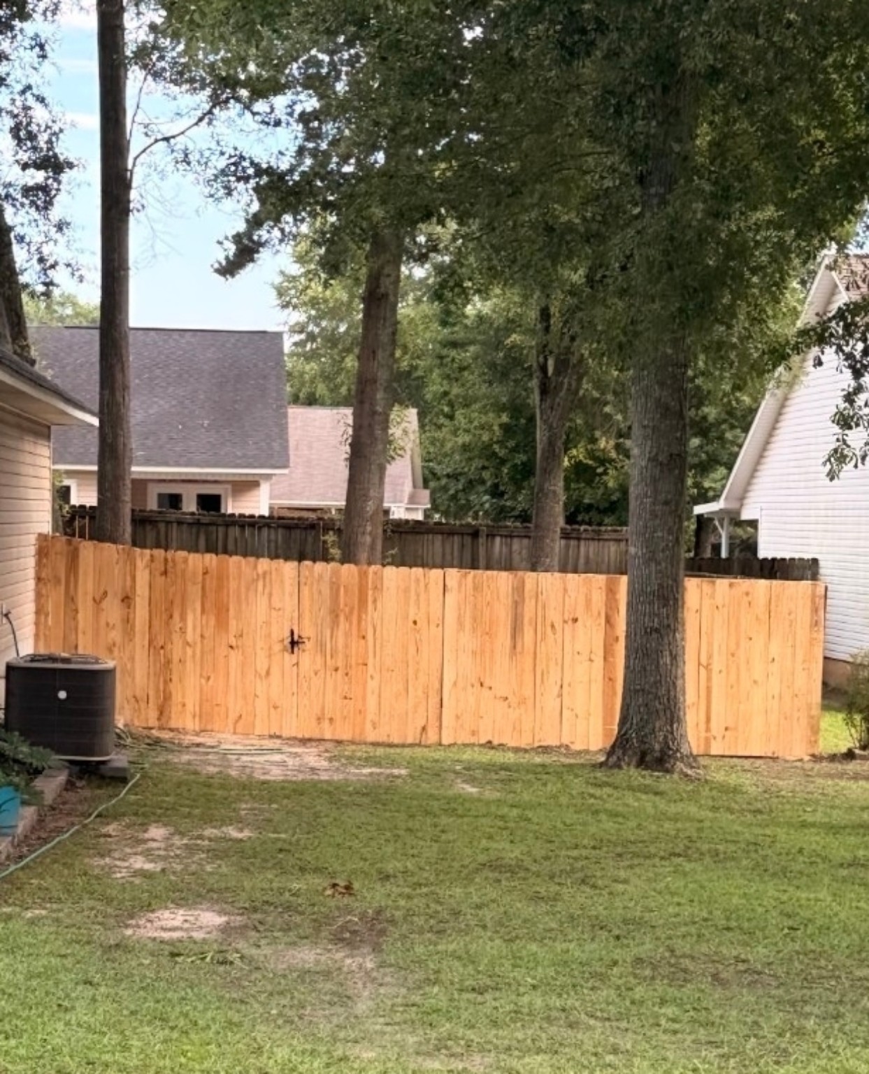 New wood privacy fence with a centered backyard gate